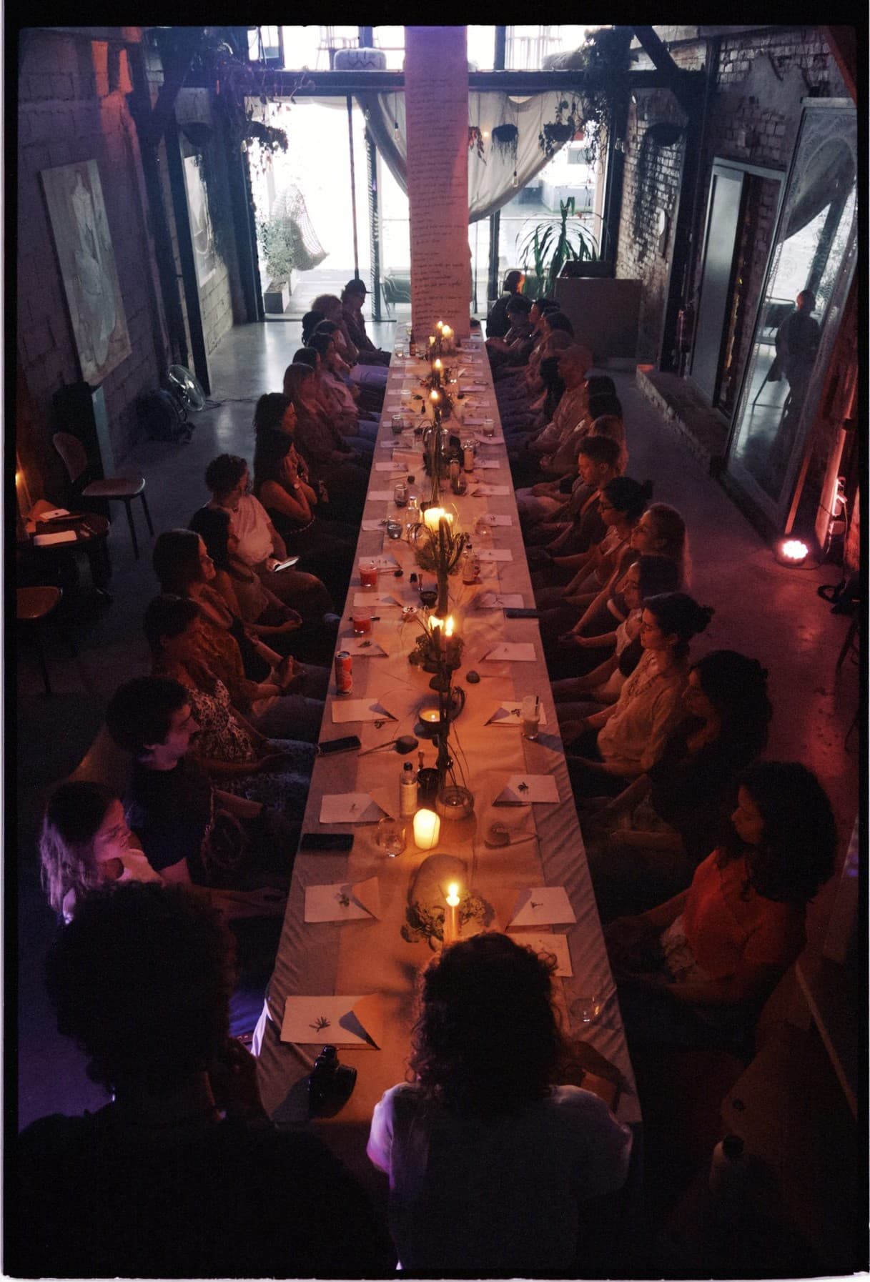 The long table at TEJÁ, full of people raising their glasses under the high roof.